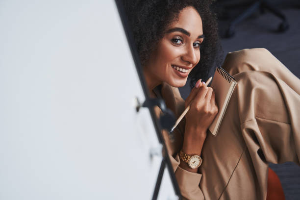 istock Happy young woman noting her ideas and looking inspired 1325044698