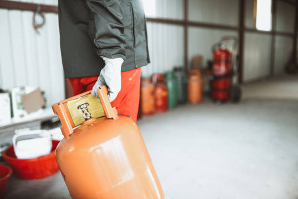 istock Worker In Protective Clothing Taking Defective Gas Cylinder To Be Repaired 1325047262