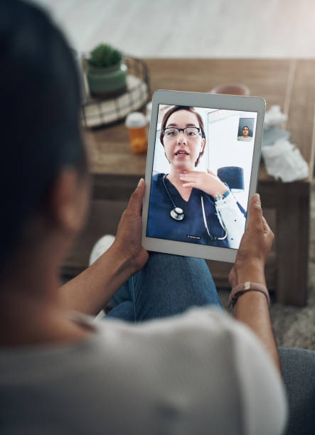 foto de una persona irreconocible en una videollamada con un médico - nurse ethnic doctor real people fotografías e imágenes de stock