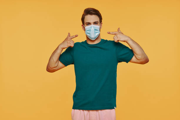 istock Handsome young man in protective face mask pointing his face and looking at camera 1325049014