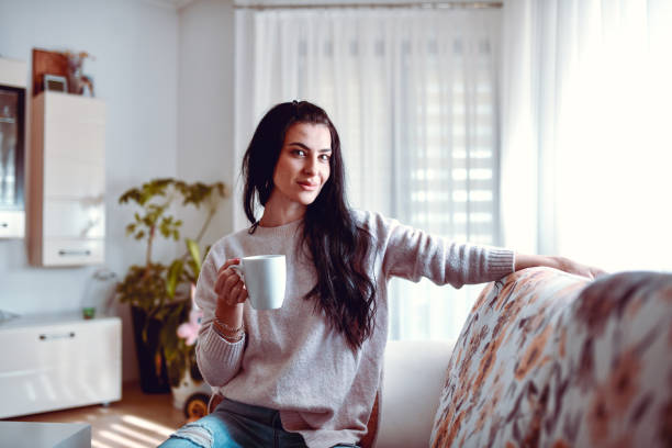 istock Smiling Female Beauty Drinking Coffee While Relaxing At Home 1325049358