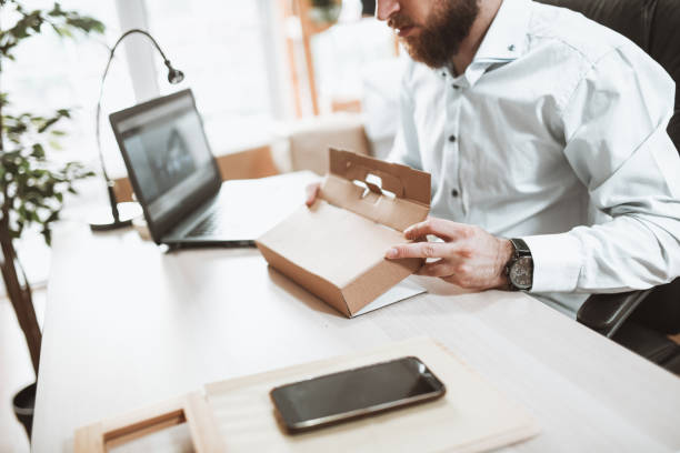 istock Bearded Delivery Office Clerk Folding Cardboard Packaging 1325052123