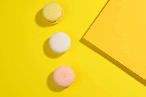 istock round multicolored macarons on a yellow background with a shadow on a yellow background. Gourmet almond flour dessert 1325052209