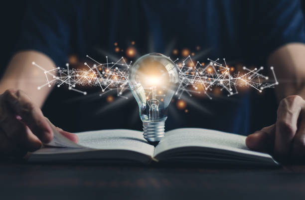 Book or textbook and glowing light bulb. Self learning or education knowledge and business studying concept. Idea of learning online or e-learning at home.