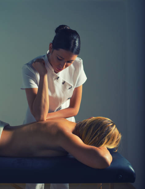 massothérapeute féminine donnant un massage en retour à la femme dans le spa de santé - physical therapy back table patient photos et images de collection