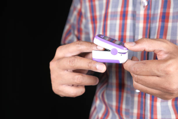 istock close up of man hand using pulse oximeter isolated on black 1325063097