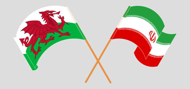 скрещенные и развевающиеся флаги уэльса и ирана - iran wales stock illustrations