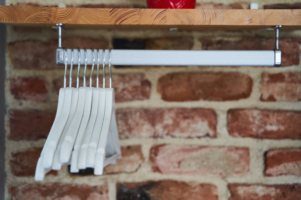 Many wooden white hangers on a rod. Store concept, sale, design, empty hanger Many wooden white hangers on a rod. Store concept, sale, design, empty hanger. High quality photo clothes hanger rod stock pictures, royalty-free photos & images
