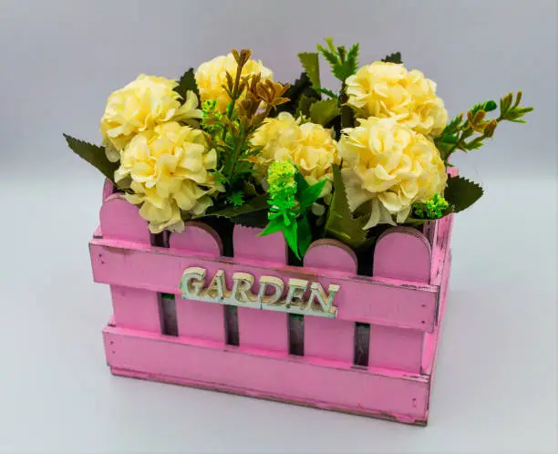 Yellow flower arrangement in pink flowerbox