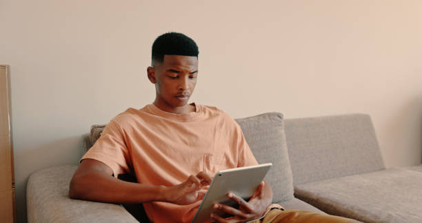 istock Shot of a young male using his tablet at home 1325068459