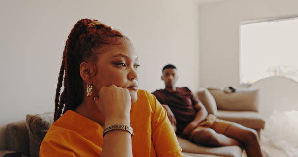 shot of a young woman ignoring her bf at home - ignorando imagens e fotografias de stock