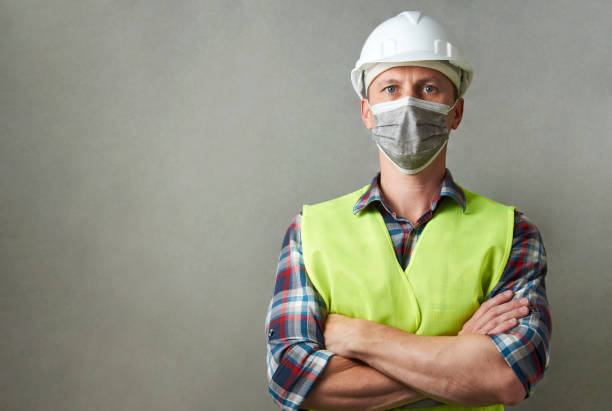 istock Worker man wearing face mask and protective hard hat 1325068552