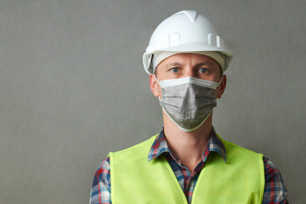 istock Worker man wearing face mask and protective hard hat 1325068555
