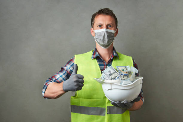 istock Construction worker with a hard hat full of dollar money 1325068592
