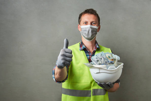 istock Construction worker with a hard hat full of dollar money 1325068595