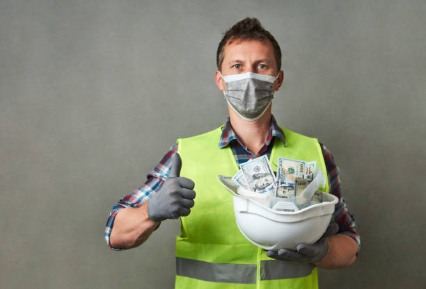 istock Construction worker with a hard hat full of dollar money 1325068598