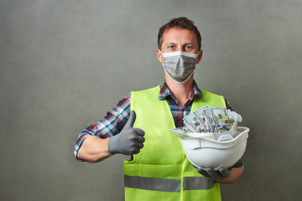 istock Construction worker with a hard hat full of dollar money 1325068605