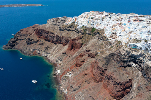 Aerial view of the picturesque old town of Oia village high above the caldera of Santorini island, Greece. Included in the picture are the famous blue domes of the Greek Orthodox chapels and small churches.