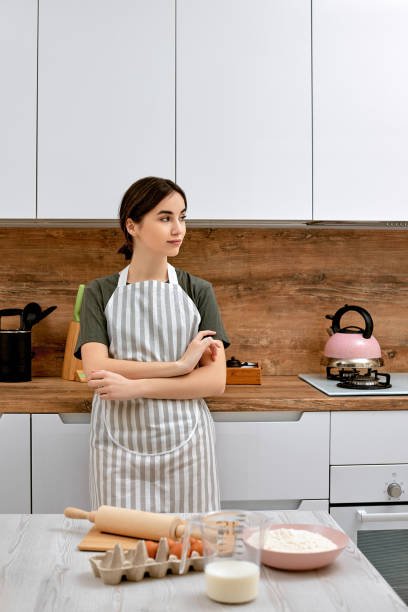 istock beautiful woman stands near table on kitchen 1325069975