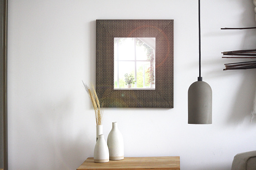 A large mosaic frame containing a mirror in a modern bright setting.