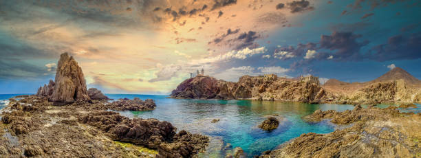 Panoramic view from the Arrecife de las Sirenas in Cabo de Gata, Spain. Sunset in Seascape with reefs and clouds Panoramic view from the Arrecife de las Sirenas in Cabo de Gata, Spain. Sunset in Seascape with reefs and clouds almeria stock pictures, royalty-free photos & images