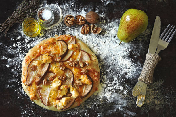 Fresh homemade pizza with cheeses, pears and walnuts. stock photo