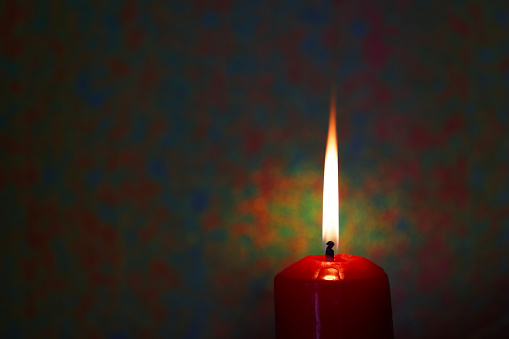 A single high flame candle with background ideal for text writing and copy space to the left side. High resolution 45Mp using Canon R5 with associate lenses.