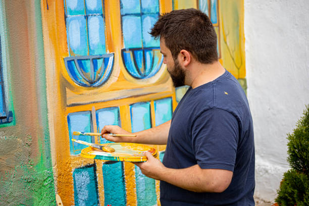 istock To get the authentic mural of small Venice, an artist using the thin paintbrush while paint the small details 1325073042