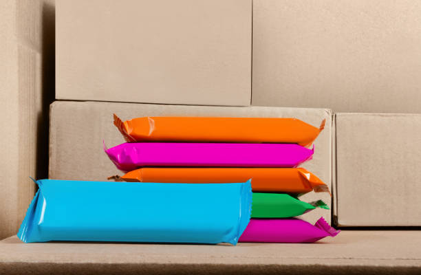 Photo of snack bars products stacked on cardboard boxes background.