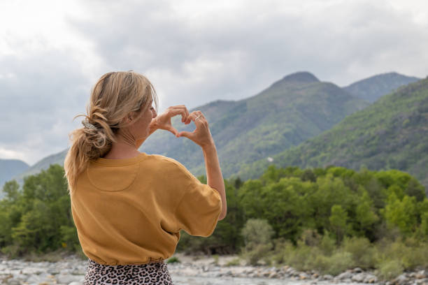istock Young woman loving nature, she makes heart with hands 1325075794