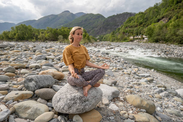 istock Young woman meditating in nature 1325075796
