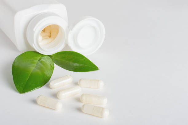 istock Dietary supplements in capsules scattered from a bottle on a white background. 1325076176