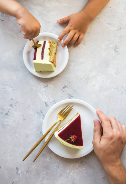 istock My cake. Mans hand and Child hands pulls out slice of cake. Raspberry cake.. Wedding dessert. Birthday party cake. Delicious dessert. 1325079226