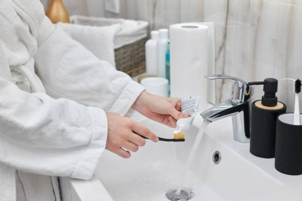 istock female hand holding toothbrush with paste in bathroom 1325080574