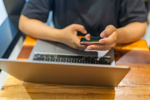 istock Woman hand using smartphone and working on laptop 1325081817