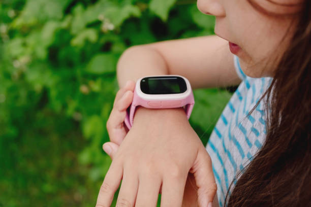 子供の手にスマートウォッチ。女の子の子供はスマートウォッチ指が含まれています。 - gps watch ストックフォトと画像