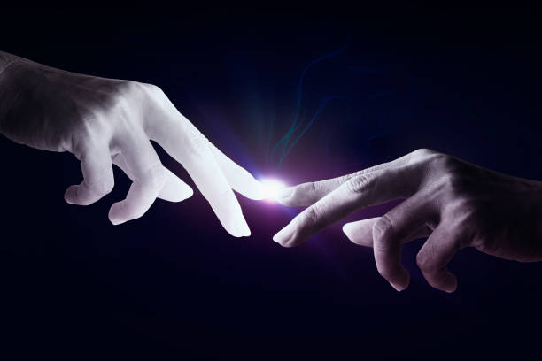 istock Human hand touching an cyborg finger about to touch human finger on dark background - Futuristic concept with copy space 1325084645