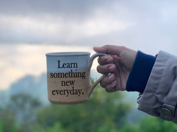 istock Coffee or tea cup in hand with text - Learn something new everyday. On foggy mountain background.i 1325084736