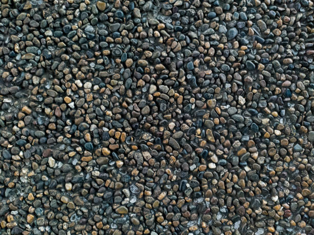 istock Small whole stones in concrete.  Stone wall.  Background from small stones. 1325086145