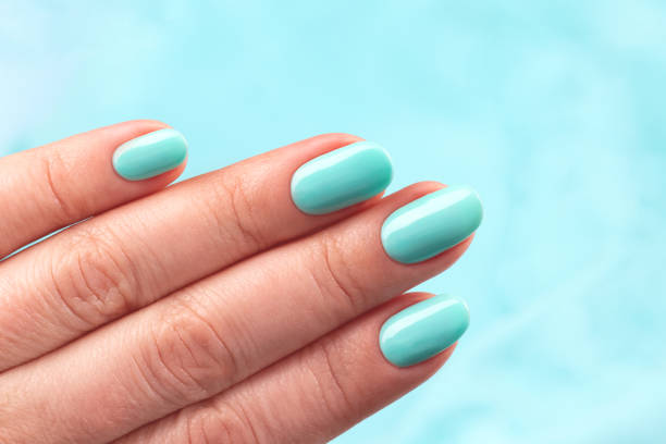 istock Hand with turquoise nails on blue background 1325087514