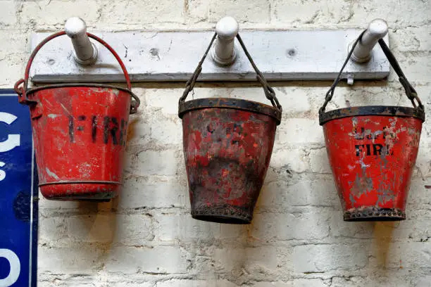 Three red fire buckets in an workshop in Beamish Village, Durham County, England, United Kingdom, 12th of June 2021