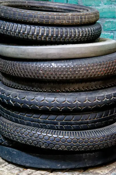 Pile of old vintage tyres inside a vintage old dusty workshop - Beamish Village, Durham County, England, United Kingdom