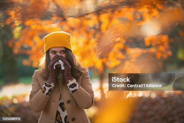 Modern 40 Years Old Woman In Brown Coat And Yellow Hat Stock Photo - Download Image Now