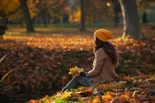 istock Seen from behind woman in brown coat and hat sitting 1325088916