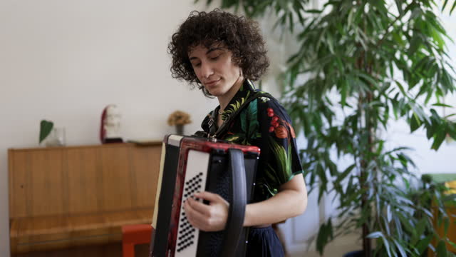 Genderqueer playing vintage accordion at home