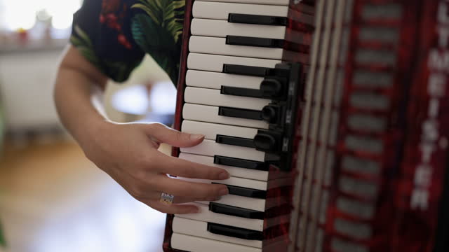 Close-up of a non-binary person playing accordion indoors
