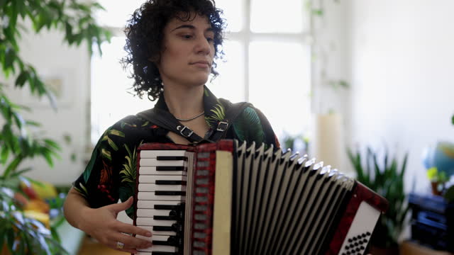 Genderqueer playing vintage accordion at home