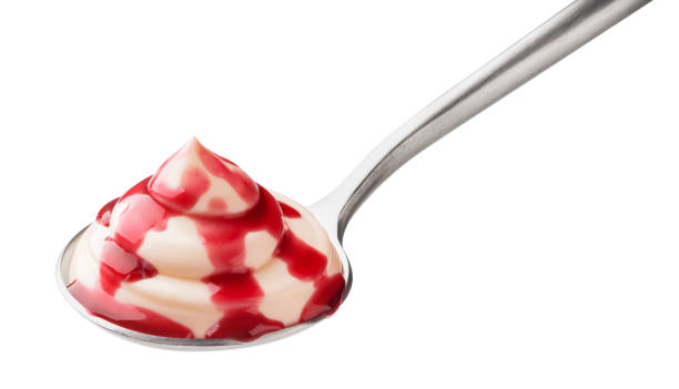 Yogurt with fruit jam in spoon isolated on white background Yogurt with fruit jam in spoon, whipped cream with berry topping isolated on white background food fruit close up strawberry stock pictures, royalty-free photos & images