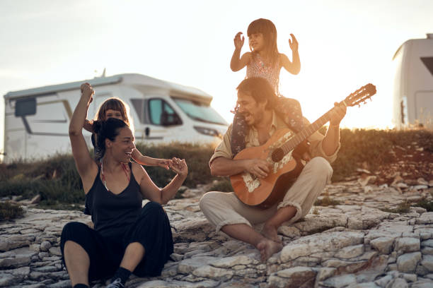 rodzina na wakacjach, śpiew, granie muzyki na gitarze i cieszenie się letnimi klimatami. - motorhome zdjęcia i obrazy z banku zdjęć