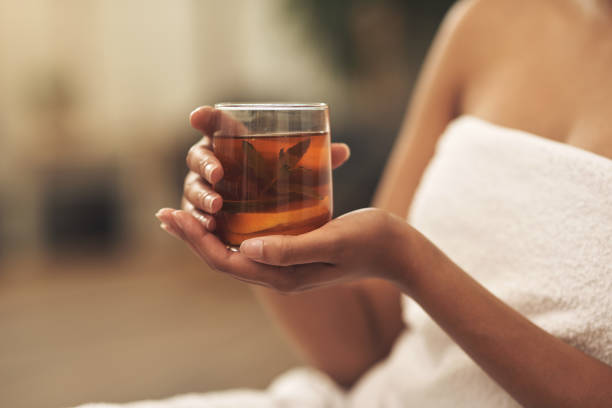 foto recortada de una mujer bebiendo té mientras se relaja en un spa - tea women beauty pampering fotografías e imágenes de stock
